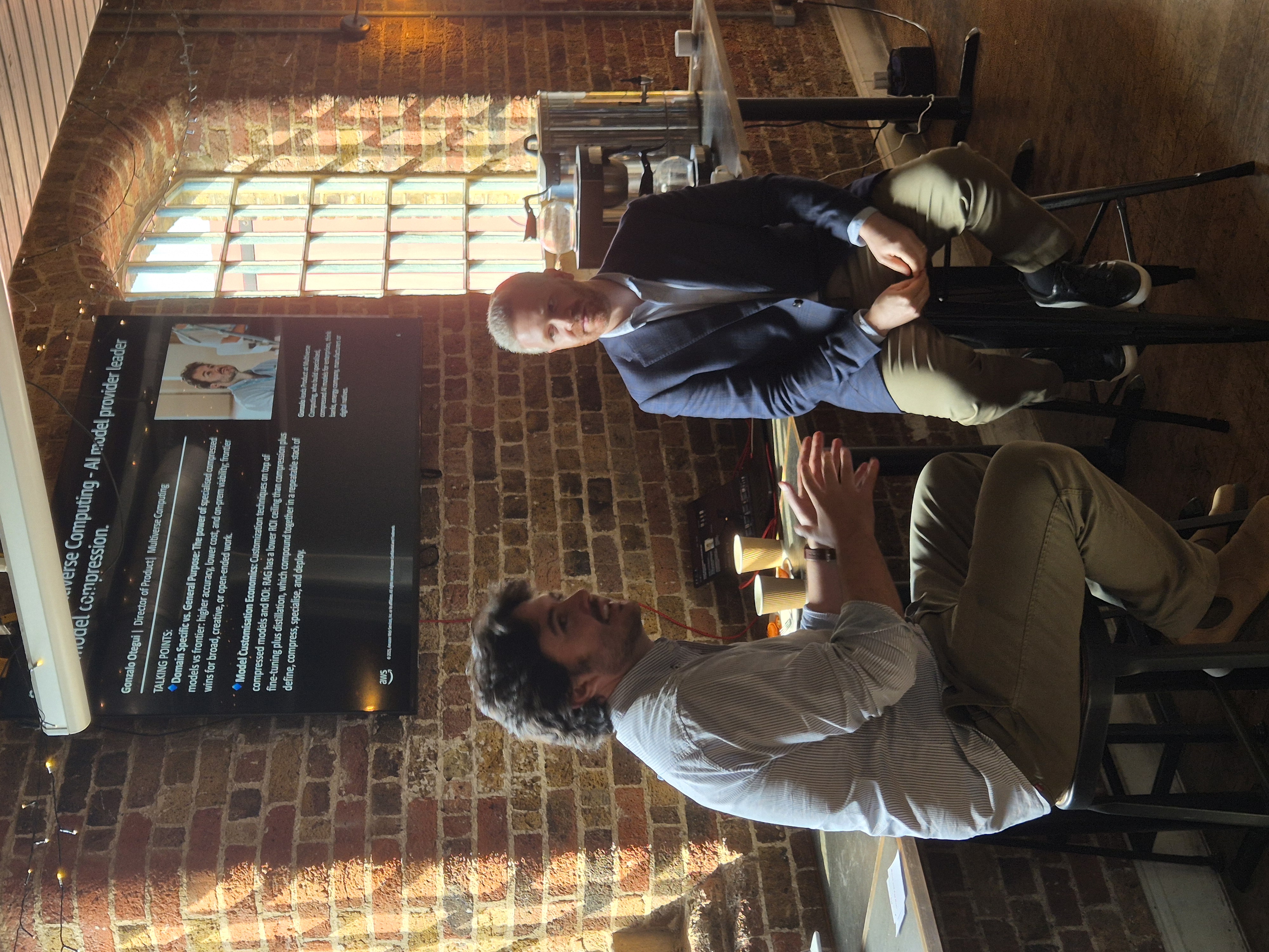 Discussion at the AI Builders Breakfast with a Multiverse Computing slide visible on screen