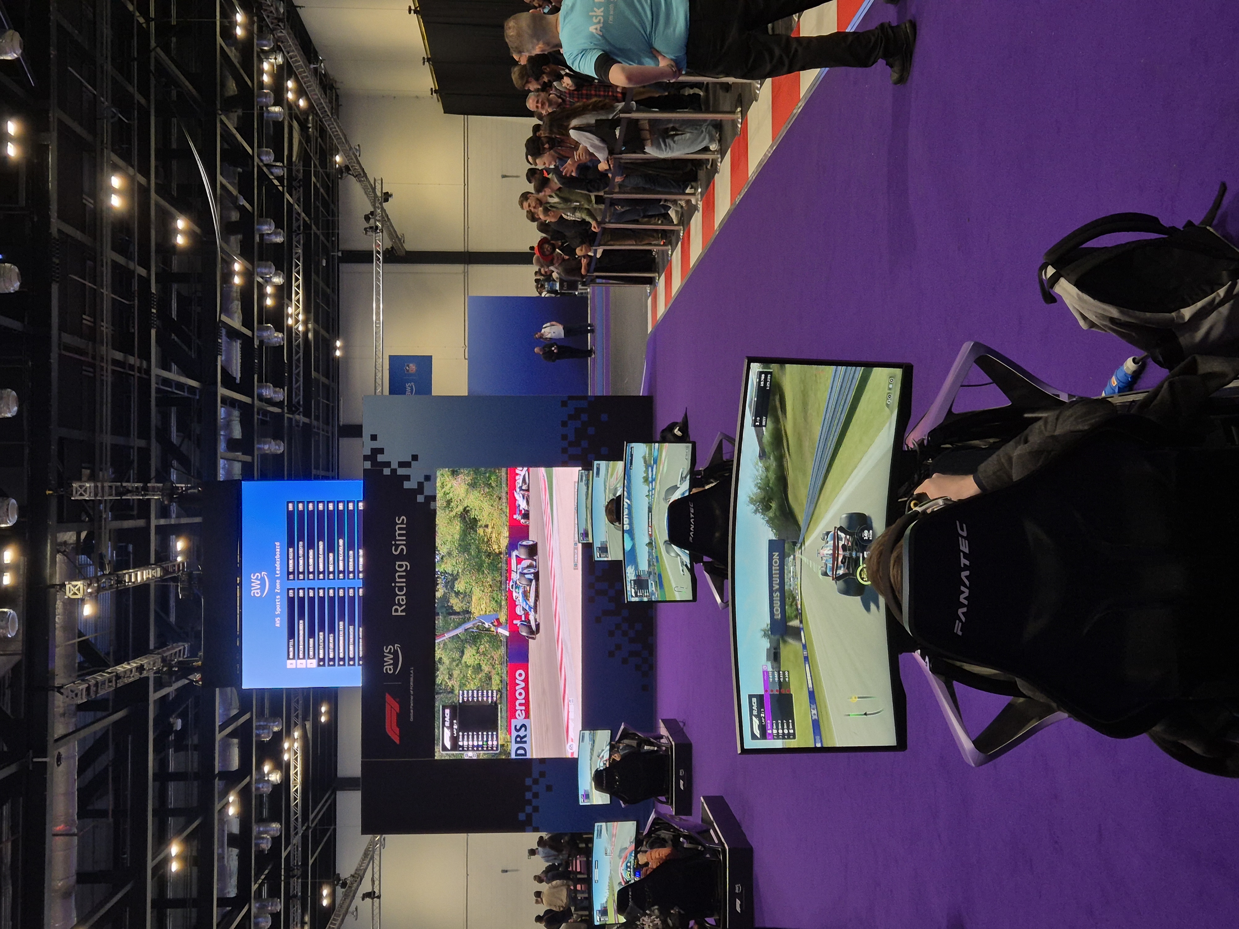 AWS Summit London 2026 Sports Zone racing simulator setup with Fanatec rigs and spectators around the track area