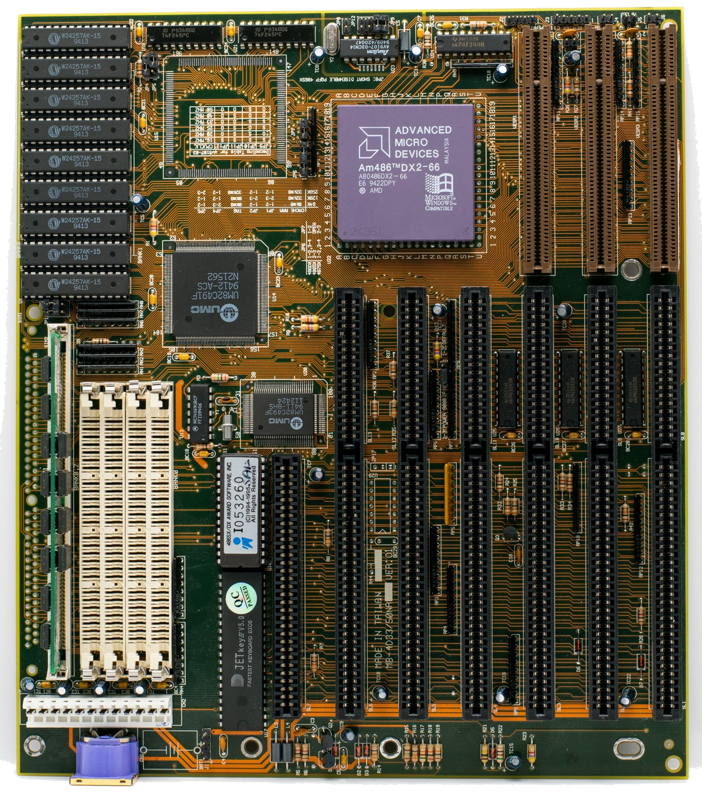 A vintage computer motherboard with an AMD processor, memory slots, expansion slots, and dense circuit traces