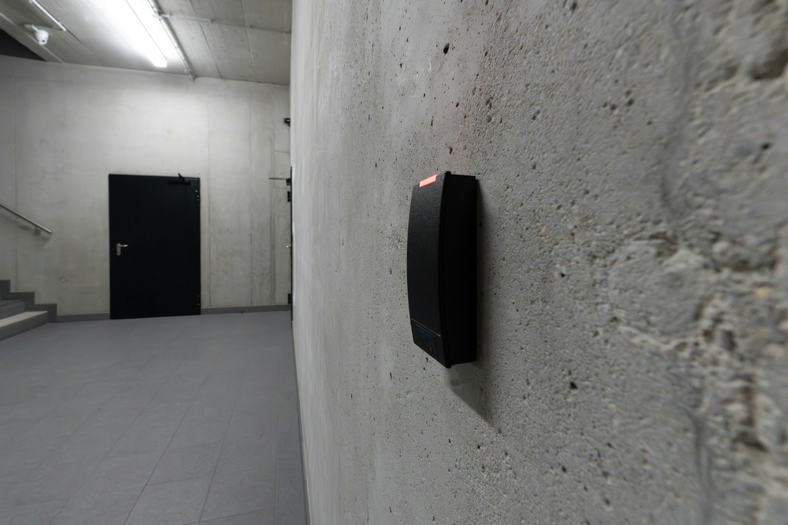 A modern office access card reader mounted beside a closed door