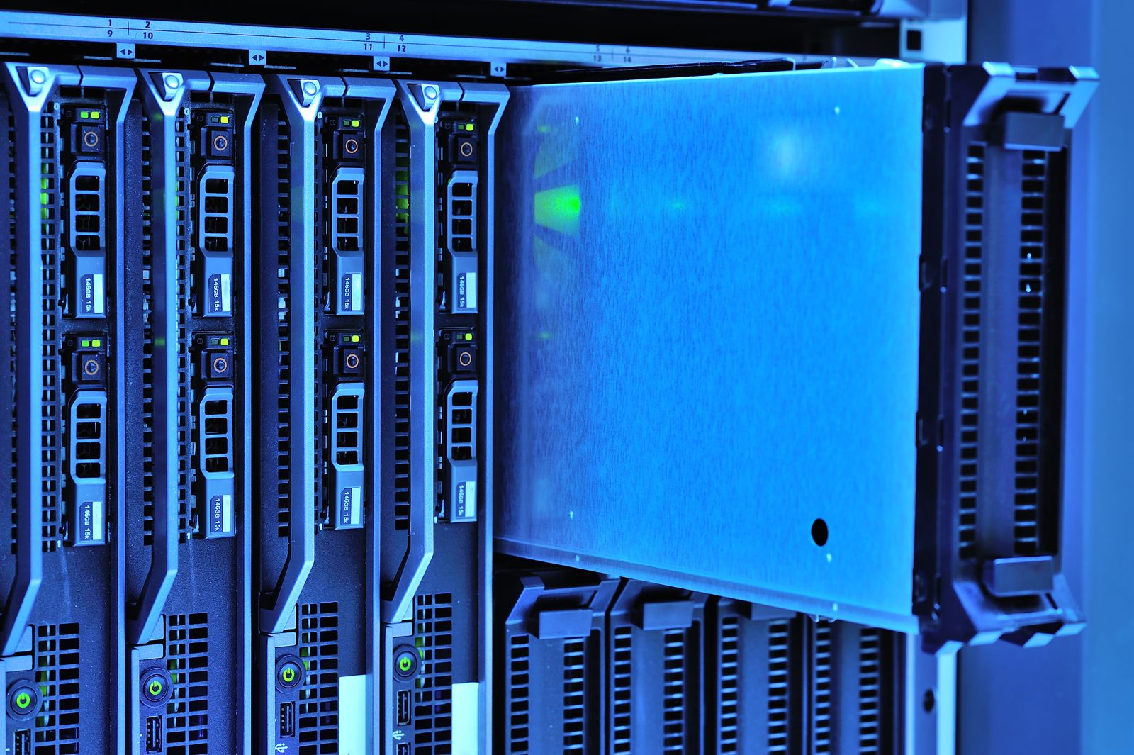 A close-up of server hardware with drive bays and blue data centre lighting